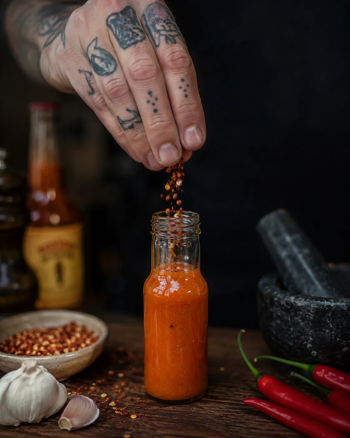 Seasoning being added to a Hot Lava bottle by hand